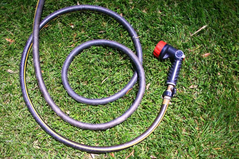 A coiled air hose lying flat on a garage floor
