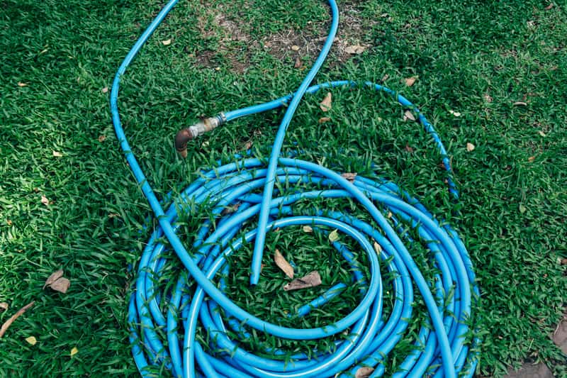 A green hybrid polymer air hose wound onto a reel drum