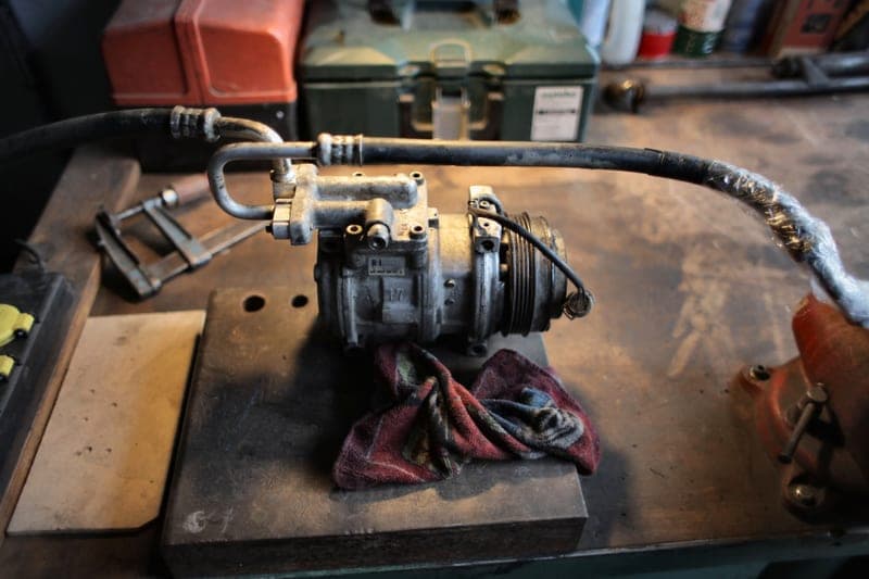 A light coiled quarter-inch air hose beside a finish nailer