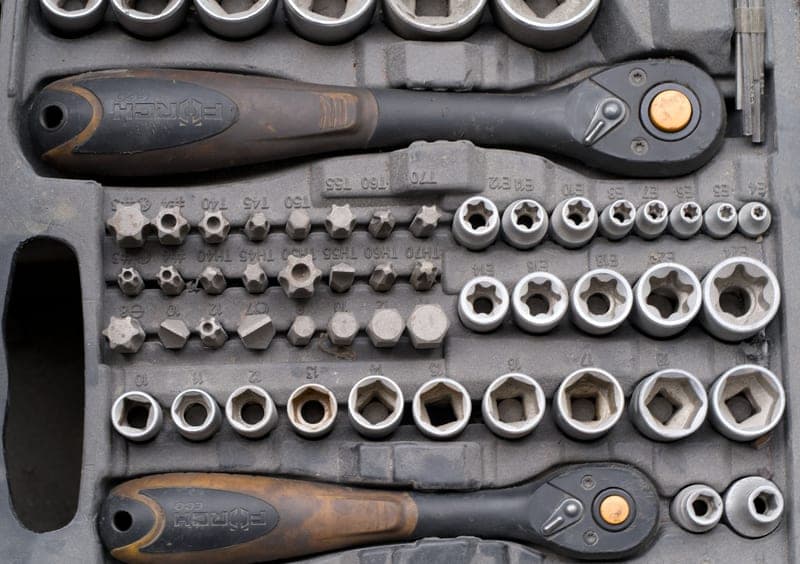 A compact air ratchet resting on an engine component