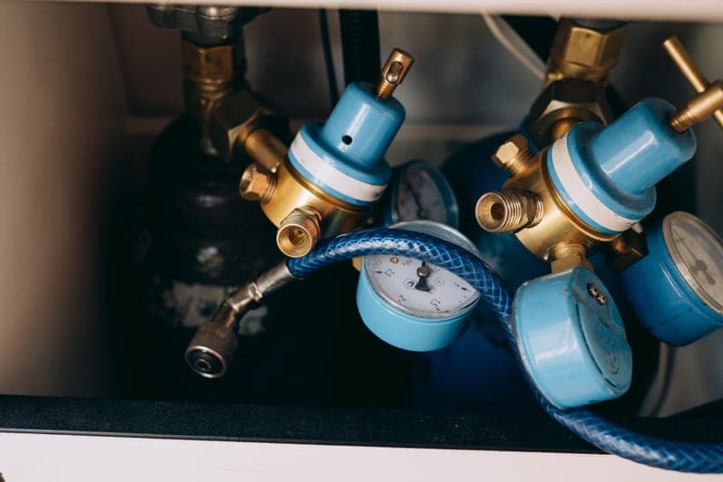 A wall-mounted compressed air filter and regulator with a gauge