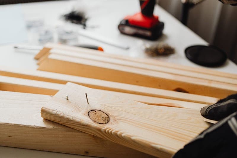 A pneumatic framing nailer resting on framing lumber