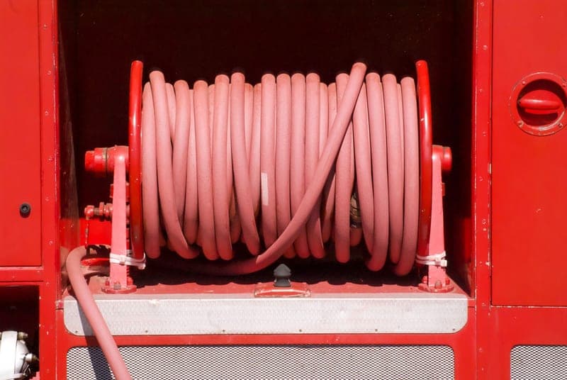 A wall-mounted retractable air hose reel in a garage
