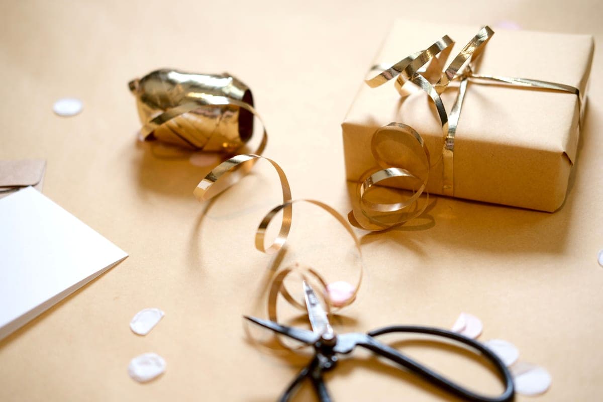 A wrapped gift box beside hand tools on a bench