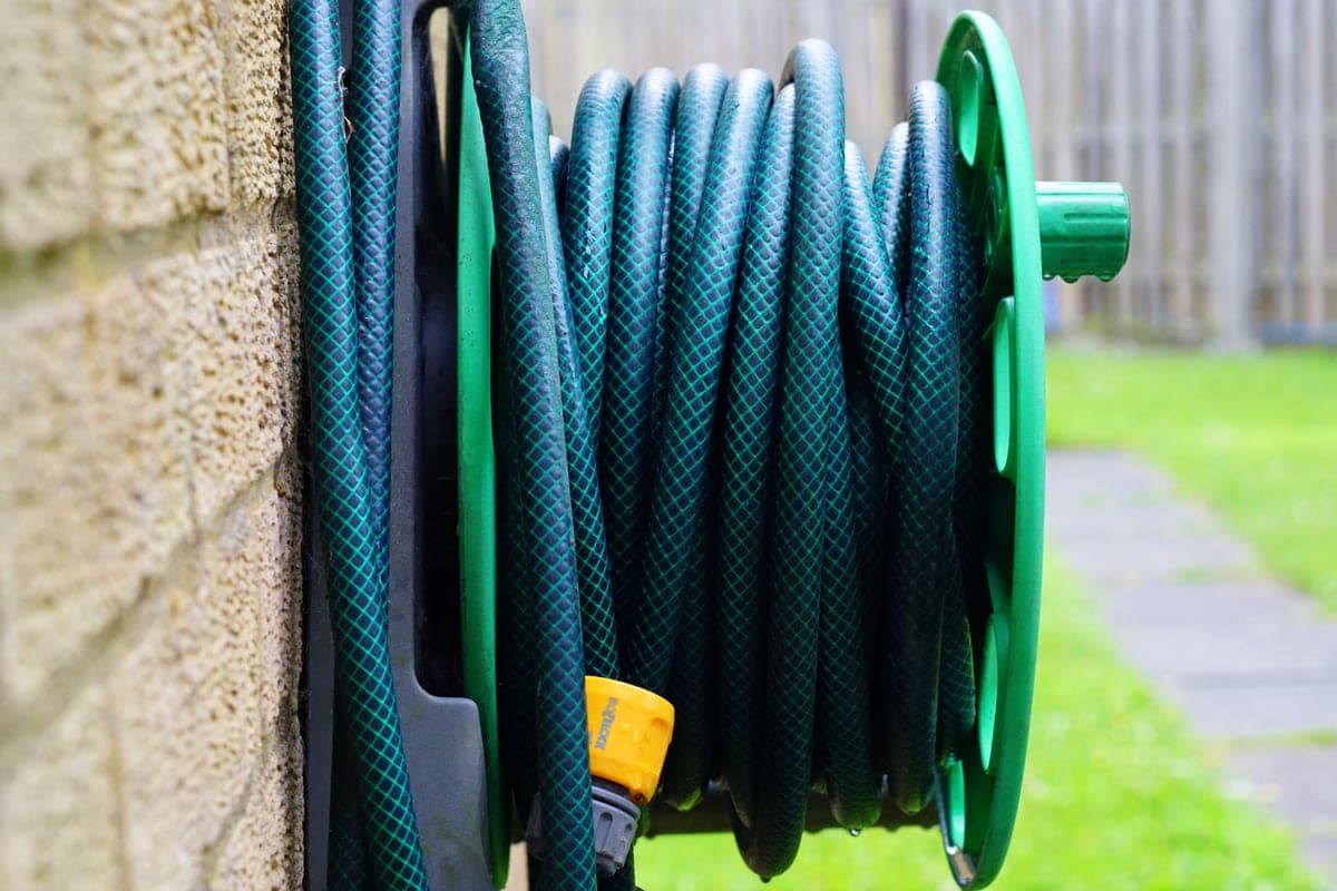 A wall-mounted hose reel with hose partly drawn out