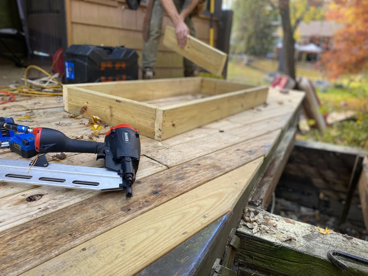 A pneumatic nail gun being used on timber