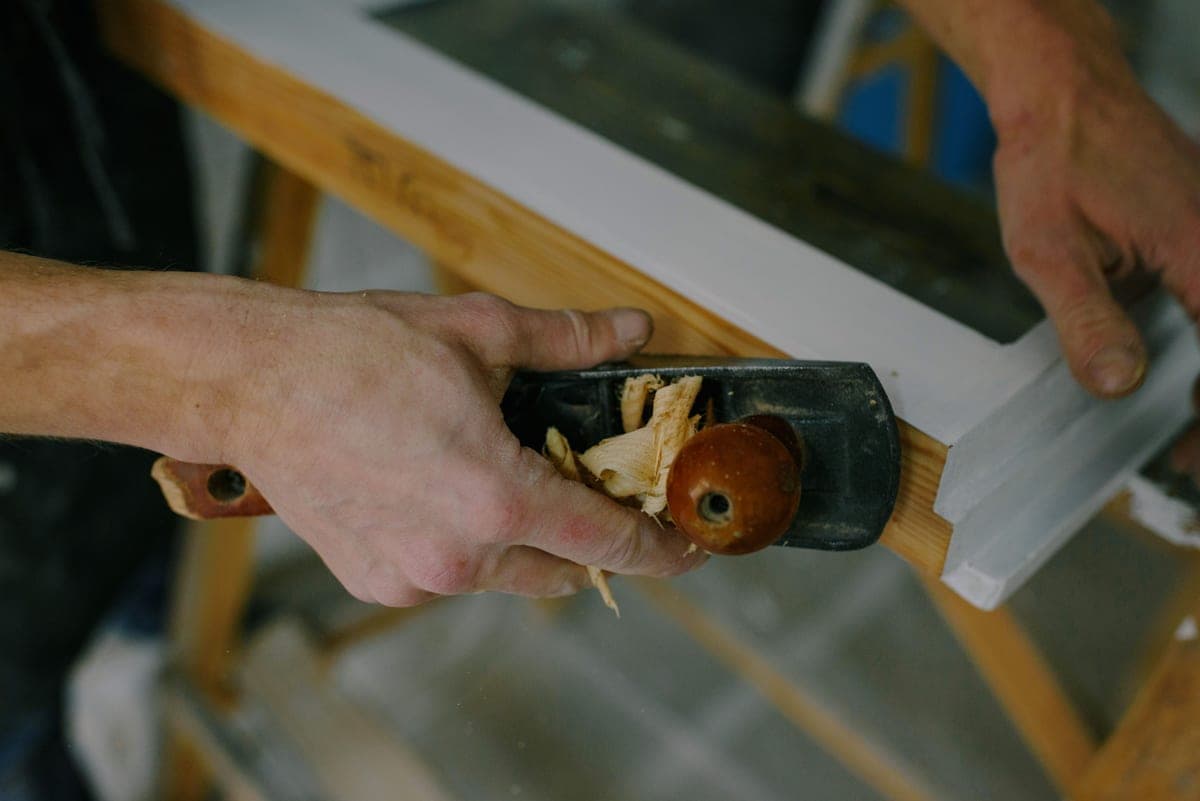 A carpenter fitting interior trim with a pneumatic finish nailer